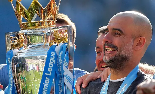 FILE - Manchester City coach Pep Guardiola lifts the English Premier League trophy after the English Premier League soccer match between Brighton and Manchester City at the AMEX Stadium in Brighton, England, Sunday, May 12, 2019. (AP Photo/Frank Augstein, File)