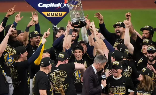 Milwaukee Brewers designated hitter Christian Yelich holds the World Series trophy with teammates after winning baseball's World Series, against the Tampa Bay Rays, Wednesday, Oct. 28, 2026, in St. Petersburg, Fla. (AP Photo/Morry Gash)