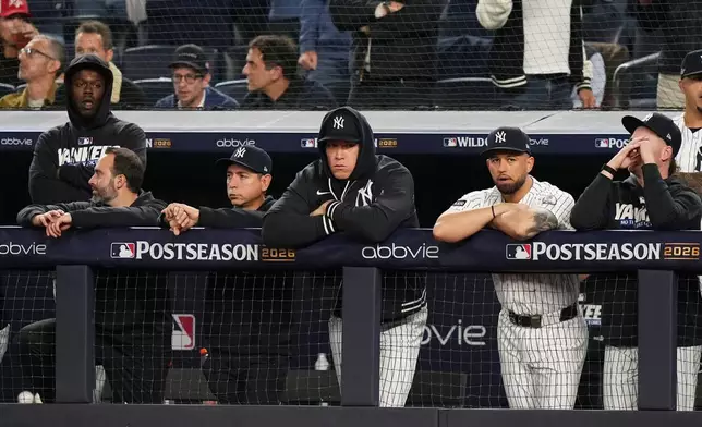 New York Yankees Aaron Judge, center, stands in the dugout with teammates during the first inning in Game 1 of baseball's American League Wild Card Series against the Boston Red Sox, Tuesday, Sept. 29, 2026, in New York. (AP Photo/Frank Franklin II)