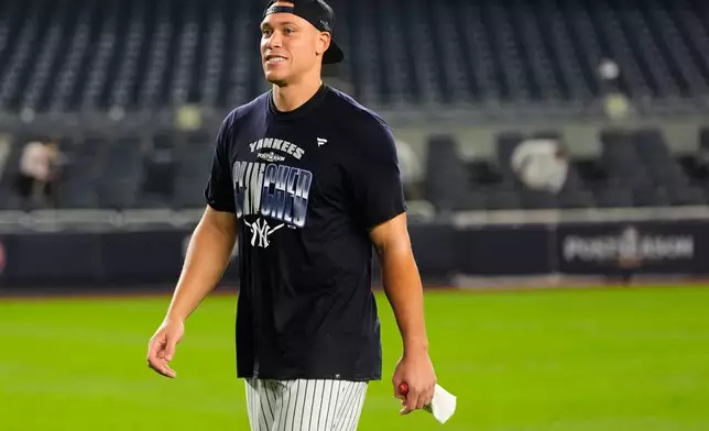 New York Yankees' Aaron Judge walks on the field to take a group photo to celebrate after winning baseball's American League Wild Card Series against the Boston Red Sox in Game 2, Wednesday, Sept. 30, 2026, in New York. (AP Photo/Yuki Iwamura)
