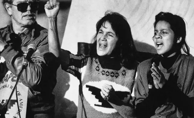 FILE - United Farm Workers leader Dolores Huerta, center, leads a rally in San Francisco's Mission District on Nov. 19, 1988, along with Howard Wallace, president of the San Francisco chapter of the UFW, left, and Maria Elena Chavez, 16, the daughter of Cesar Chavez, right, as part of a national boycott of what the UFW claims is the dangerous use of pesticides on table grapes. (AP Photo/Court Mast, File)