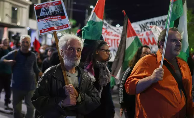 A protester holds an anti-war placard as others hold Palestinian flags during a demonstration against the official visit of U.S. Secretary of State Marco Rubio to Athens, Tuesday, Oct. 6, 2026. (AP Photo/Ismini Vlassopoulou)