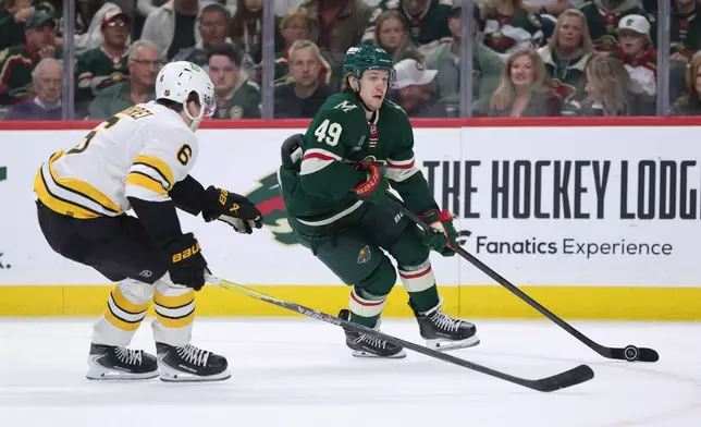 Minnesota Wild right wing Maxim Shabanov (49) skates with the puck while Boston Bruins defenseman Mason Lohrei (6) defends during the first period of an NHL hockey game Saturday, Oct. 3, 2026, in St. Paul, Minn. (AP Photo/Bailey Hillesheim)