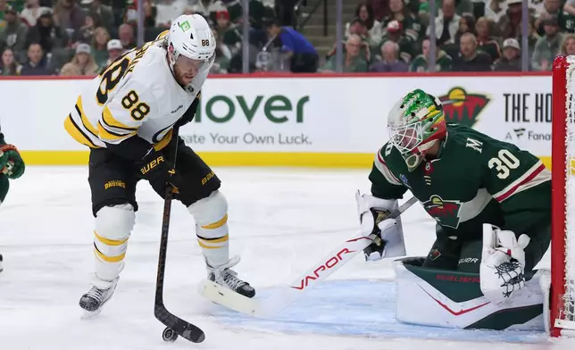 Boston Bruins right wing David Pastrnak (88) skates with the puck while Minnesota Wild goaltender Jesper Wallstedt (30) defends during the second period of an NHL hockey game Saturday, Oct. 3, 2026, in St. Paul, Minn. (AP Photo/Bailey Hillesheim)
