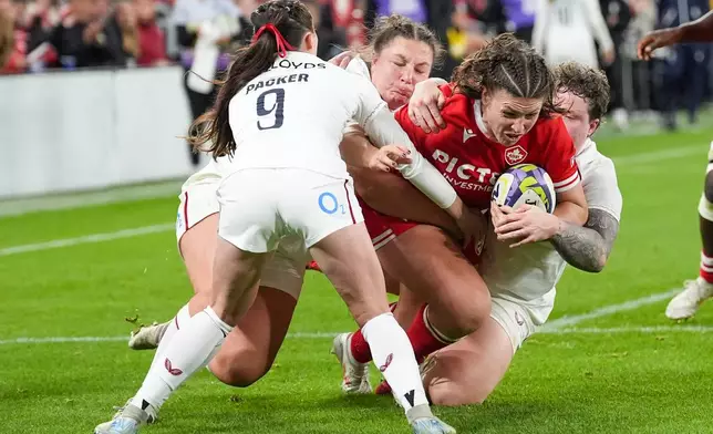 Canada's DaLeaka Menin, second from right, is tackled by England's Hannah Botterman, right, during the first half of a women's rugby match in Toronto, Friday, Oct. 16, 2026. (Arlyn McAdorey/The Canadian Press via AP)