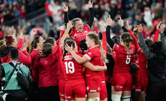 Canada players celebrate after their win over England in a women's rugby match in Toronto, Friday, Oct. 16, 2026. (Arlyn McAdorey/The Canadian Press via AP)
