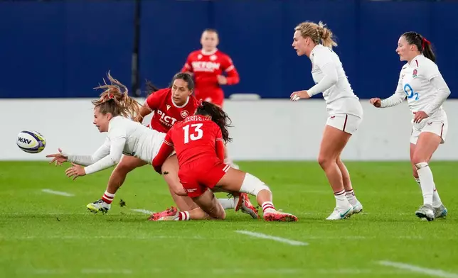England's Zoe Harrison, left, is tackled by Canada's Florence Symonds (13) during the first half of a Canadian Football League game in Ottawa, Ontario, Friday, Oct. 16, 2026. (Adrian Wyld/The Canadian Press via AP)