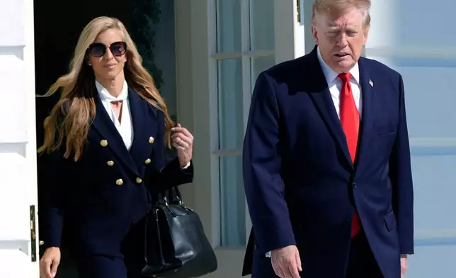 President Donald Trump walks out along with White House press secretary Katie Zacharia to talk to reporters before boarding Marine One on the South Lawn of the White House, Tuesday, Oct. 13, 2026, in Washington. (AP Photo/Manuel Balce Ceneta)