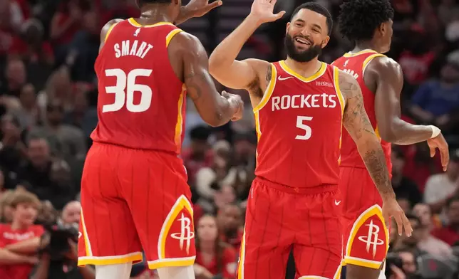 Houston Rockets guards Fred VanVleet (5) and Marcus Smart (36) celebrate the Rockets' lead against the Dallas Mavericks during the first half of an NBA basketball game, Wednesday, Oct. 21, 2026, in Houston. (AP Photo/Karen Warren)