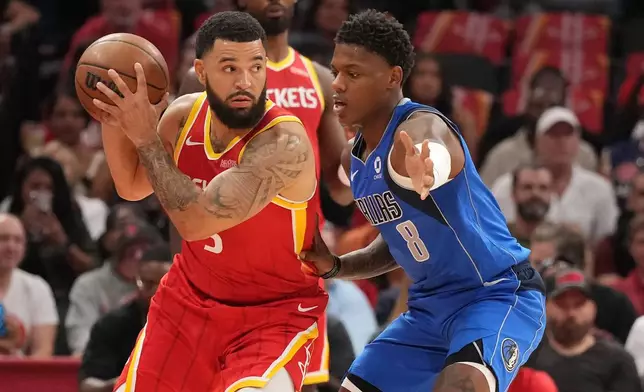 Houston Rockets guard Fred VanVleet, left, controls the ball against Dallas Mavericks guard Marcus Sasser during the first half of an NBA basketball game, Wednesday, Oct. 21, 2026, in Houston. (AP Photo/Karen Warren)