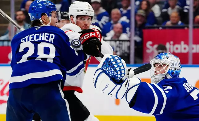 Toronto Maple Leafs goaltender Sergei Bobrovsky (72) makes a save as teammate Troy Stecher (28) battles with Ottawa Senators' Shane Pinto (12) during the third period of an NHL hockey game in Toronto, Saturday, Oct. 3, 2026. (Frank Gunn/The Canadian Press via AP)