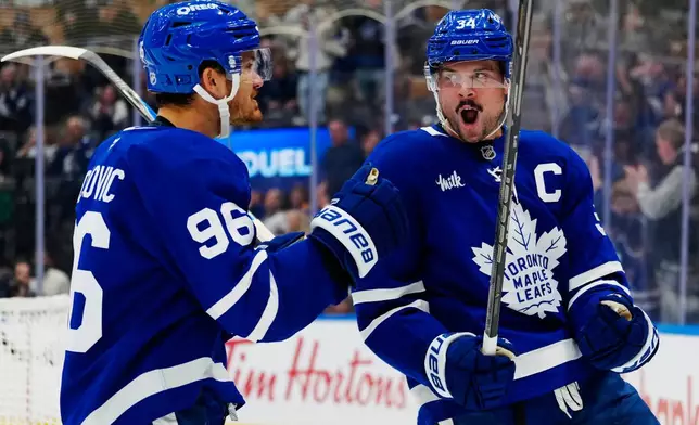Toronto Maple Leafs' Auston Matthews (34) celebrates after his goal against the Ottawa Senators with Jack Roslovic (96) during the second period of an NHL hockey game in Toronto, Saturday, Oct. 3, 2026. (Frank Gunn/The Canadian Press via AP)