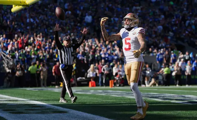 San Francisco 49ers wide receiver Mike Evans reacts after catching a touchdown pass from quarterback Brock Purdy during the first half of an NFL football game against the Seattle Seahawks, Sunday, Oct. 11, 2026, in Seattle. (AP Photo/Lindsey Wasson)