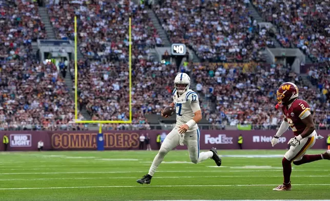 Indianapolis Colts quarterback Daniel Jones (17) gets past Washington Commanders cornerback Amik Robertson (2) to score a touchdown during an NFL football game in London, Sunday, Oct. 4, 2026. (AP Photo/David J. Phillip)