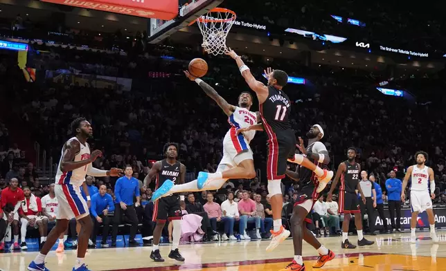 Detroit Pistons forward John Collins (20) shoots under pressure from Miami Heat guard Klay Thompson (11) during the first half of an NBA basketball game, Friday, Oct. 23, 2026, in Miami. (AP Photo/Rebecca Blackwell)