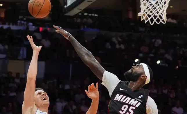 Detroit Pistons forward Duncan Robinson (55) is defended by Miami Heat forward Bobby Portis Jr. (95) during the first half of an NBA basketball game, Friday, Oct. 23, 2026, in Miami. (AP Photo/Rebecca Blackwell)