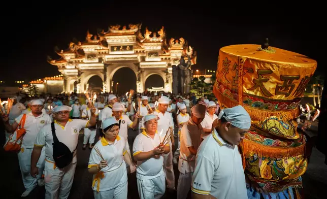 Devotees follow an ornate ceremonial canopy during a night procession marking the Nine Emperor Gods Festival at Si Thian Kong Temple in Kuala Pilah, Malaysia, Wednesday, Oct. 14, 2026. (AP Photo/Vincent Thian)