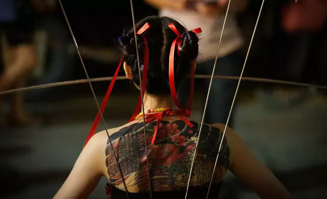 A devotee, with metal rods piercing her body, takes part in a ritual on the final day of the Nine Emperor Gods Festival on Penang island, Malaysia, Sunday, Oct. 18, 2026. (AP Photo/Vincent Thian)