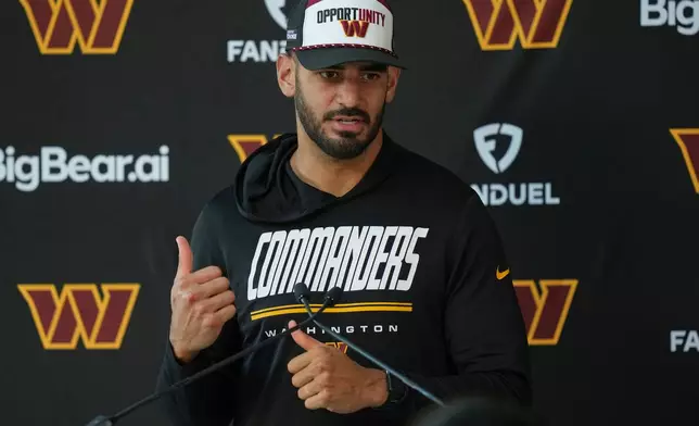 Washington Commanders quarterback Marcus Mariota (8) speaks to the media following NFL football practice in London, Wednesday, Sept. 30, 2026, (AP Photo/Alastair Grant)