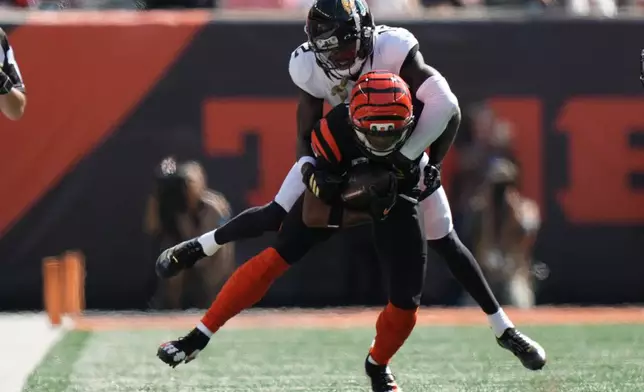 Jacksonville Jaguars cornerback Travis Hunter (12) tackles Cincinnati Bengals wide receiver Ja'marr Chase (1) during an NFL football game in Cincinnati, Sunday, Oct. 4, 2026. (AP Photo/Joshua A. Bickel)