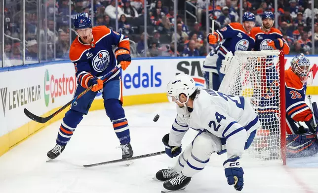 Edmonton Oilers' Connor Murphy (5) moves the puck as Toronto Maple Leafs' Brandon Duhaime (24) defends during the third period of an NHL hockey game in Edmonton, Alberta, Saturday, Oct. 24, 2026. (Codie McLachlan/The Canadian Press via AP)