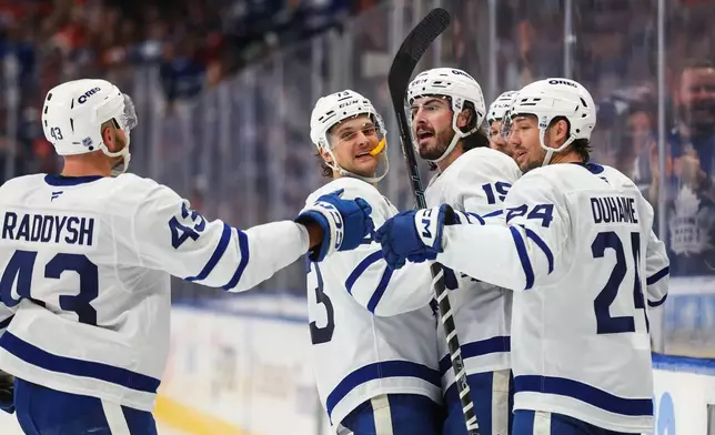 From front left to right, Toronto Maple Leafs' Darren Raddysh, Teddy Blueger, Zack MacEwan and Brandon Duhaime celebrate after a goal against the Edmonton Oilers during the third period of an NHL hockey game in Edmonton, Alberta, Saturday, Oct. 24, 2026. (Codie McLachlan/The Canadian Press via AP)