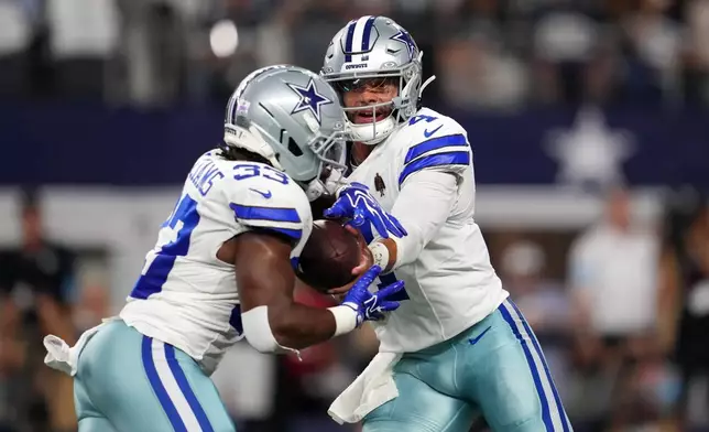 Dallas Cowboys quarterback Dak Prescott (4) hands off to running back Javonte Williams (33) as Williams scores a touchdown against the Tampa Bay Buccaneers in the first half of an NFL football game in Arlington, Texas on Thursday, Oct. 8, 2026. (AP Photo/Tony Gutierrez)
