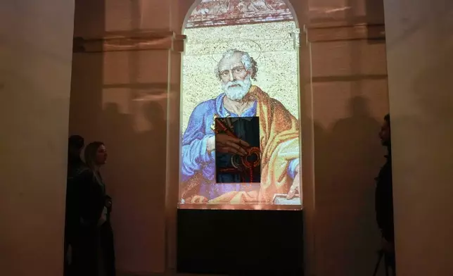 FILE - An image of St. Peter is projected on a screen during the press preview for the exhibition "Petros eni," which is part of the project "St. Peter's Basilica: AI-Enhanced Experience" at the Vatican, Nov. 9, 2024. (AP Photo/Gregorio Borgia, File)