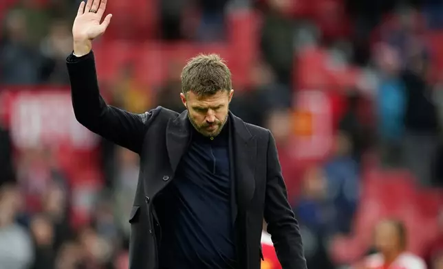 Manchester United's head coach Michael Carrick waves to supporters after his team lost the English Premier League soccer match between Manchester United and Bournemouth in Manchester, England, Sunday, Oct. 25, 2026. (AP Photo/Dave Thompson)