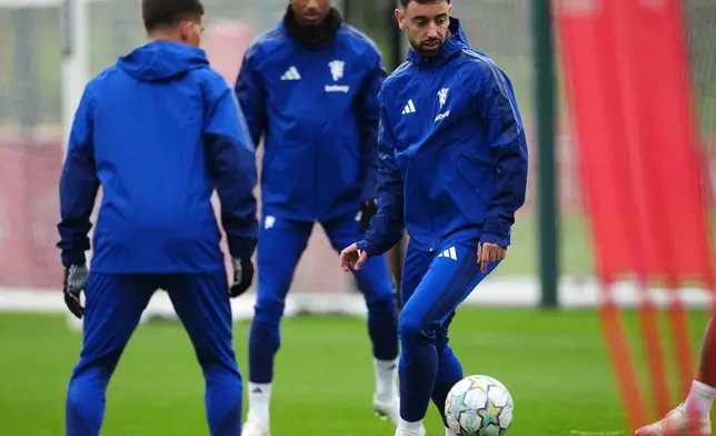 Manchester United's Bruno Fernandes (right) attends a training session at Carrington Training Centre, Manchester, England, Monday Oct. 12, 2026. (Martin Rickett/PA via AP)