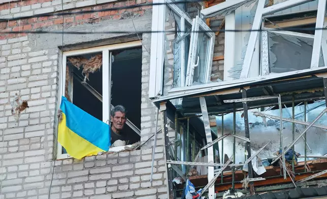 A man looks through a broken window in a residential house damaged by a Russian strike in Zaporizhzhia, Ukraine, Friday, Oct. 9, 2026. (AP Photo/Kateryna Klochko)