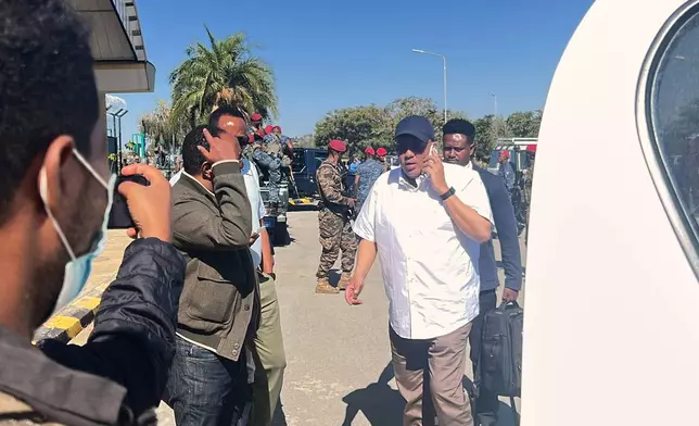 In this photo taken with a smartphone Getachew Reda, center, a former Tigray leader and adviser to Ethiopian Prime Minister Abiy Ahmed, speaks on a cellphone at the airport in Mekelle, Ethiopia, Sunday, Oct. 11, 2026. (AP Photo/Filmon Equar Hailu)