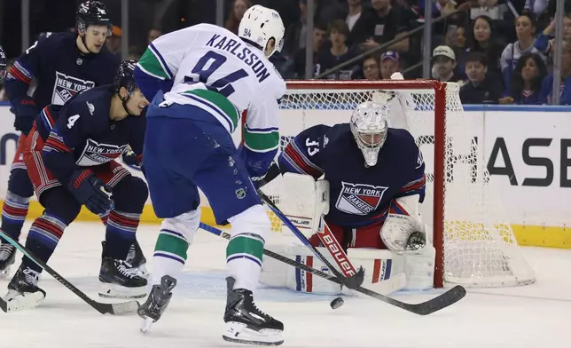 New York Rangers goaltender Dylan Garand (33) blocks a shot by Vancouver Canucks' Linus Karlsson (94) during the second period of an NHL hockey game Sunday, Oct. 11, 2026, in New York. (AP Photo/Pamela Smith)