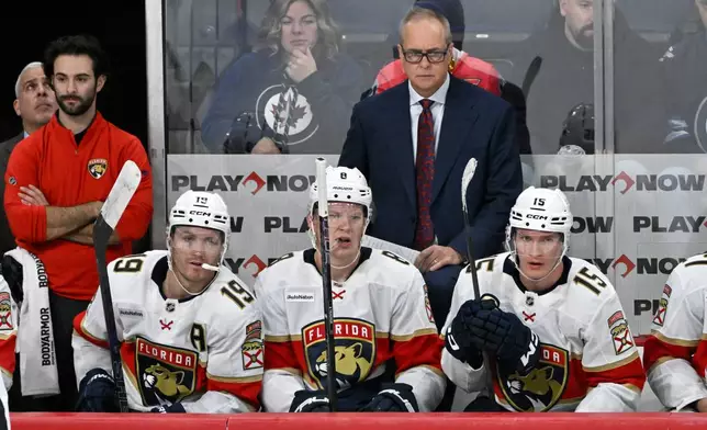 Florida Panthers' Matthew Tkachuk (19), Brady Tkachuk (8), Anton Lundell (15) and head coach Paul Maurice watch the action against the Winnipeg Jets during third period NHL action in Winnipeg on Tuesday, Oct. 27, 2026. (Fred Greenslade/The Canadian Press via AP)