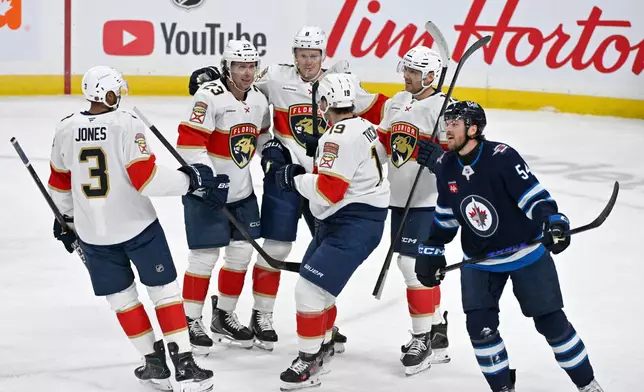 Florida Panthers' Carter Verhaeghe (23) celebrates his goal against the Winnipeg Jets with Seth Jones (3), Brady Tkachuk (8), Matthew Tkachuk (19) and Sam Reinhart (13) during first period of an NHL game in Winnipeg, Tuesday, Oct. 27, 2026. (Fred Greenslade/The Canadian Press via AP)