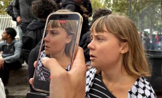 Activist Greta Thunberg answers journalist's questions as she attends a gathering in front of the Paul Eluard high school during a protest against under-resourced schools in Saint-Denis, outside Paris, Tuesday Oct. 13, 2026. (AP Photo/John Leicester)