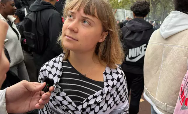 Activist Greta Thunberg answers journalist's questions as she attends a gathering in front of the Paul Eluard high school during a protest against under-resourced schools in Saint-Denis, outside Paris, Tuesday Oct. 13, 2026. (AP Photo/John Leicester)