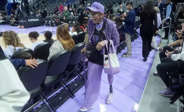 Golden State Valkyries fan Cynthia Cheak hands out wristbands to fans before an WNBA basketball game between the Valkyries and Seattle Storm in San Francisco, Sept. 19, 2026. (AP Photo/Jeff Chiu)