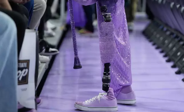Golden State Valkyries fan Cynthia Cheak walks on a prosthetic leg as she hands out wristbands to fans before an WNBA basketball game between the Valkyries and Seattle Storm in San Francisco, Sept. 19, 2026. (AP Photo/Jeff Chiu)