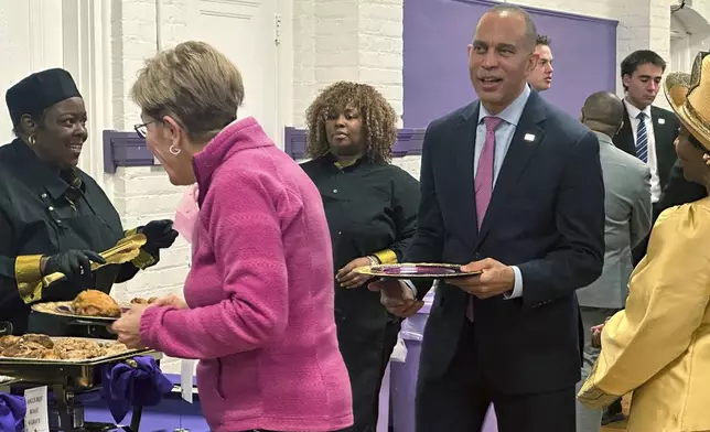 In this photo taken with a smartphone, House Democratic Leader Hakeem Jeffries, standing with Rep. Marcy Kaptur, D-Ohio, join a church luncheon after Sunday services at the Worship Center of Toledo on Oct. 18, 2026, in Toledo, Ohio. (AP Photo/Lisa Mascaro)