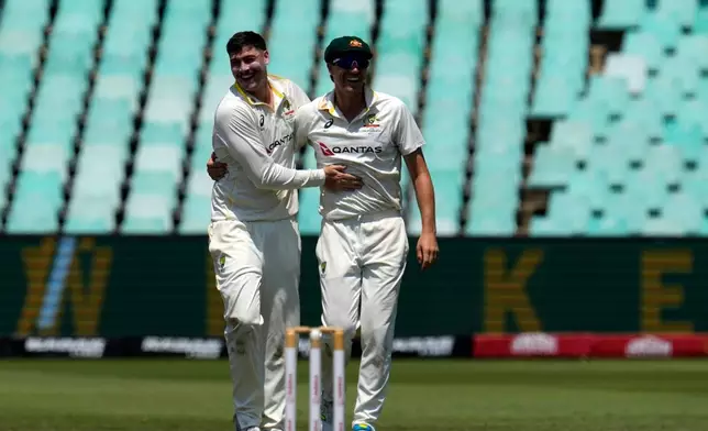 Australia's Matt Renshaw, left, celebrates with his captain Pat Cummins, after taking a wicket on day five of the first cricket test match between South Africa and Australia, in Durban, South Africa, Tuesday, Oct. 13, 2026. (AP Photo/Themba Hadebe)