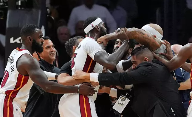 People try to separate Miami Heat forward Bobby Portis Jr., center, and Dallas Mavericks forward Daniel Gafford, right, during an altercation in the first half of an NBA basketball game, Monday, Oct. 26, 2026, in Miami. (AP Photo/Rebecca Blackwell)