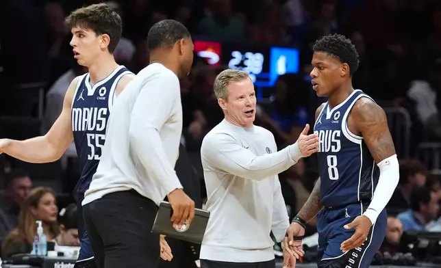 Dallas Mavericks head coach Dusty May, center, talks with guard Marcus Sasser (8) as he leaves the court during the first half of an NBA basketball game against the Miami Heat, Monday, Oct. 26, 2026, in Miami. (AP Photo/Rebecca Blackwell)