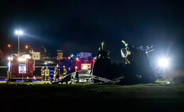 First responders stand next to the wreckage of an Italian CH-47 Chinook helicopter crashed in Brcko, Bosnia, Thursday, Oct. 29, 2026. (AP Photo/Predrag Simic)