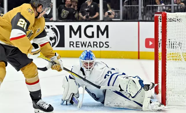Toronto Maple Leafs goalie Sergei Bobrovsky, right, stops a shot by Vegas Golden Knights' Brett Howden (21) during the second period of an NHL hockey game Thursday, Oct. 8, 2026, in Las Vegas. (AP Photo/David Becker)