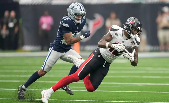 Houston Texans wide receiver Nico Collins makes a catch as Dallas Cowboys cornerback Reddy Steward defends during the second half of an NFL football game in Houston, Sunday, Oct. 4, 2026. (AP Photo/Ashley Landis)