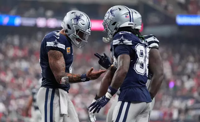 Dallas Cowboys wide receiver Ceedee Lamb, right, celebrates his touchdown with quarterback Dak Prescott during the second half of an NFL football game against the Houston Texans in Houston, Sunday, Oct. 4, 2026. (AP Photo/Ashley Landis)