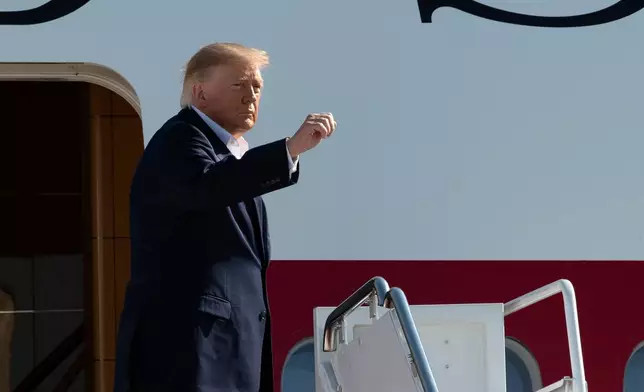 President Donald Trump waves while boarding Air Force One at Joint Base Andrews, Md., Tuesday, Oct. 27, 2026. (AP Photo/Cliff Owen)