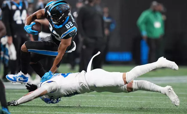 Detroit Lions linebacker Jimmy Rolder, bottom, tackles Carolina Panthers tight end Tommy Tremble (82) during an NFL football game in Charlotte, N.C., Sunday, Oct. 4, 2026. (AP Photo/Jacob Kupferman)