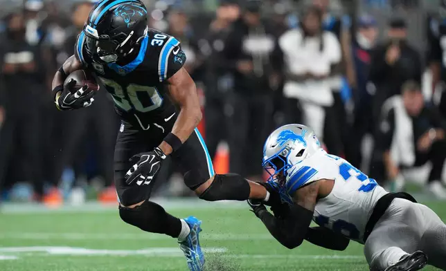 Detroit Lions safety Chuck Clark (36) tackles Carolina Panthers running back Chuba Hubbard (30) during an NFL football game in Charlotte, N.C., Sunday, Oct. 4, 2026. (AP Photo/Jacob Kupferman)